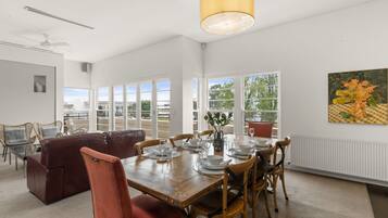 Un comedor con una mesa de madera dispuesta para seis personas, rodeada de sillas de madera.