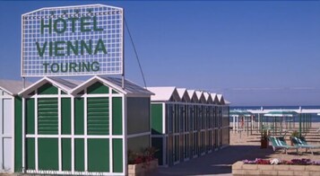 Una playa cerca, sillas reclinables de playa, sombrillas