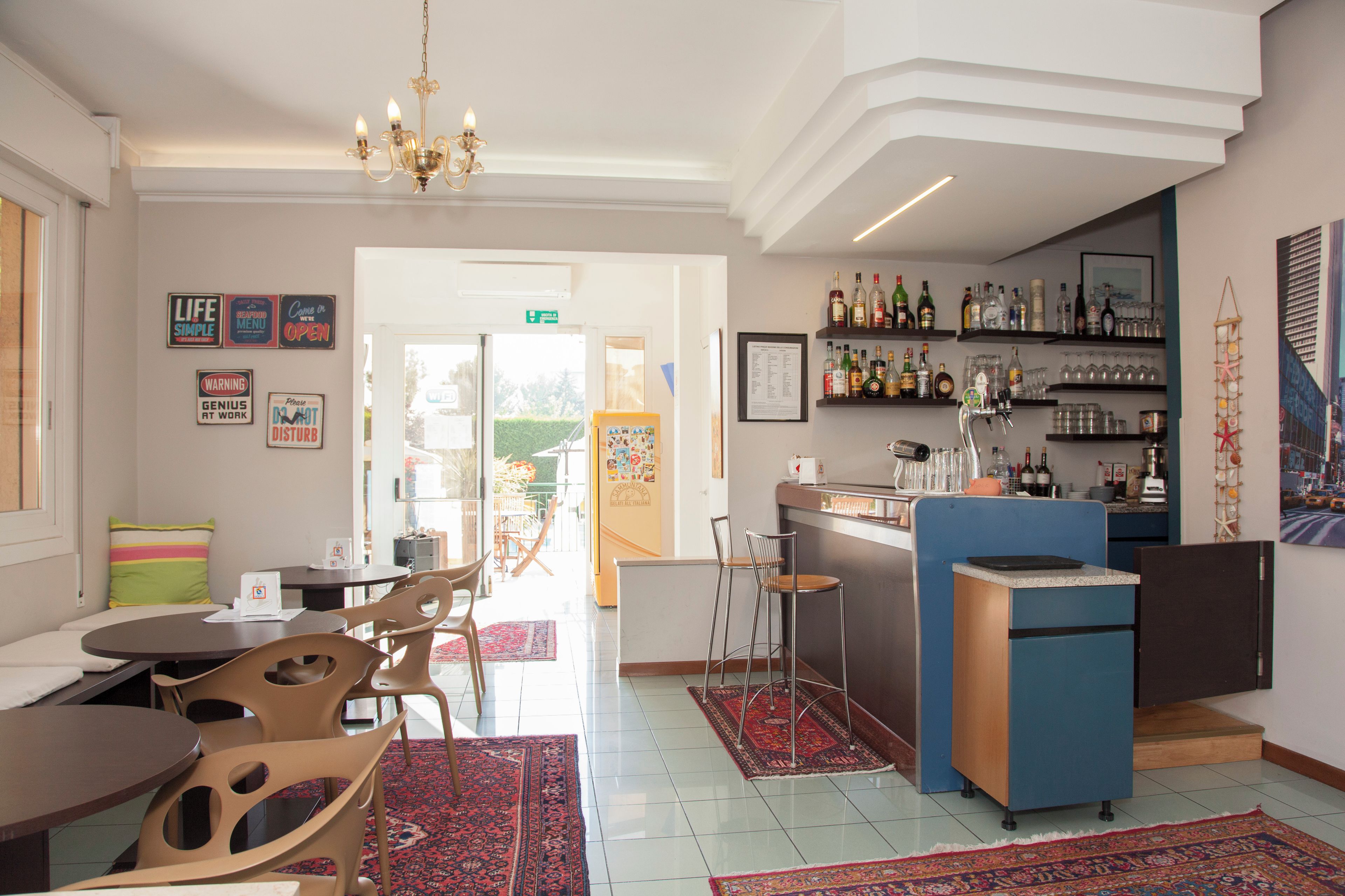 Un interior de restaurante con barra, asientos y vistas al exterior.