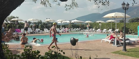 Een seizoensgebonden buitenzwembad, parasols voor strand/zwembad