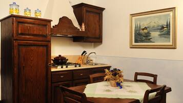 Una cocina con armarios de madera, una estufa y una mesa de comedor con sillas.