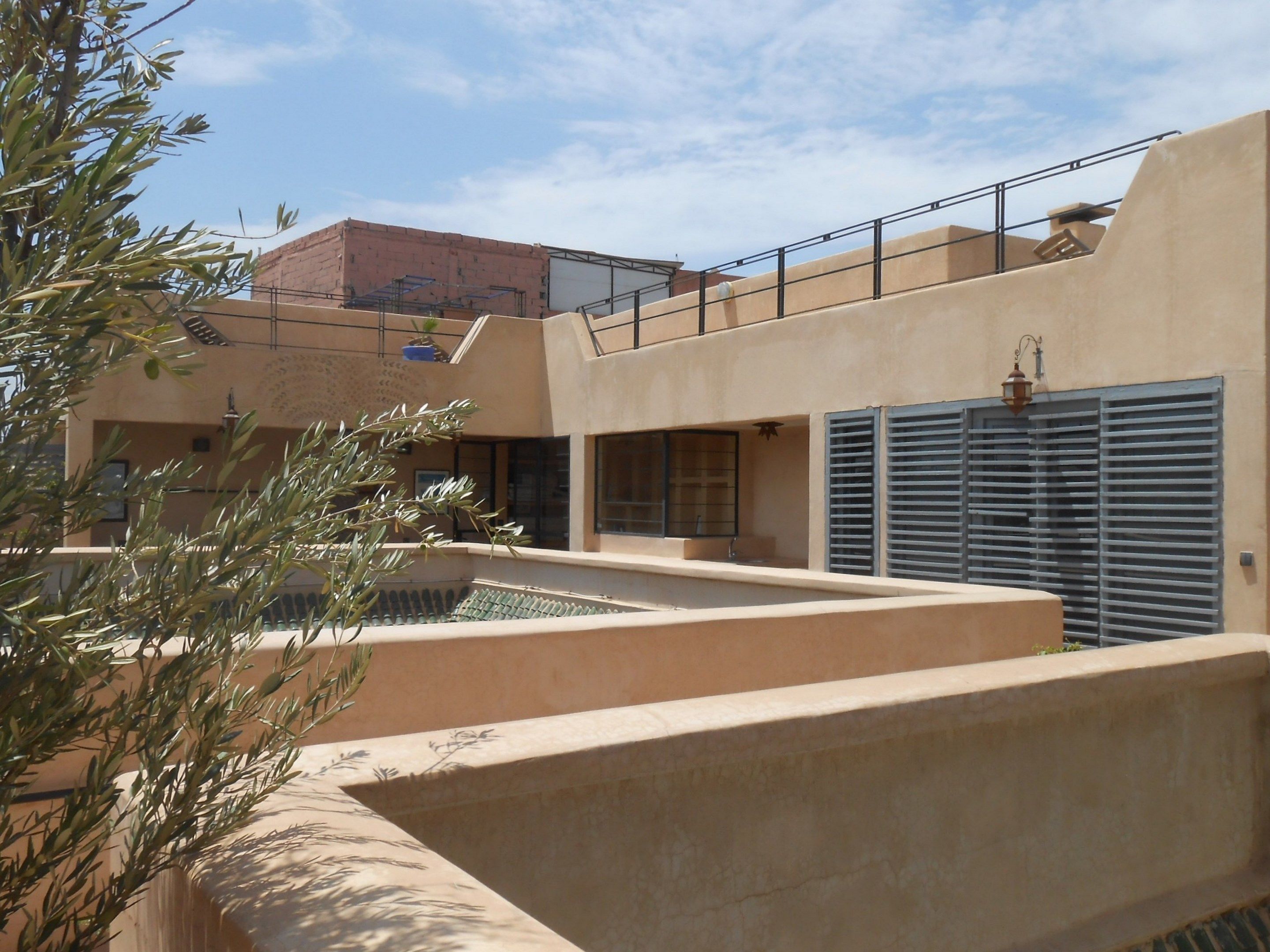 A modern building with a flat roof, large windows, and a balcony.