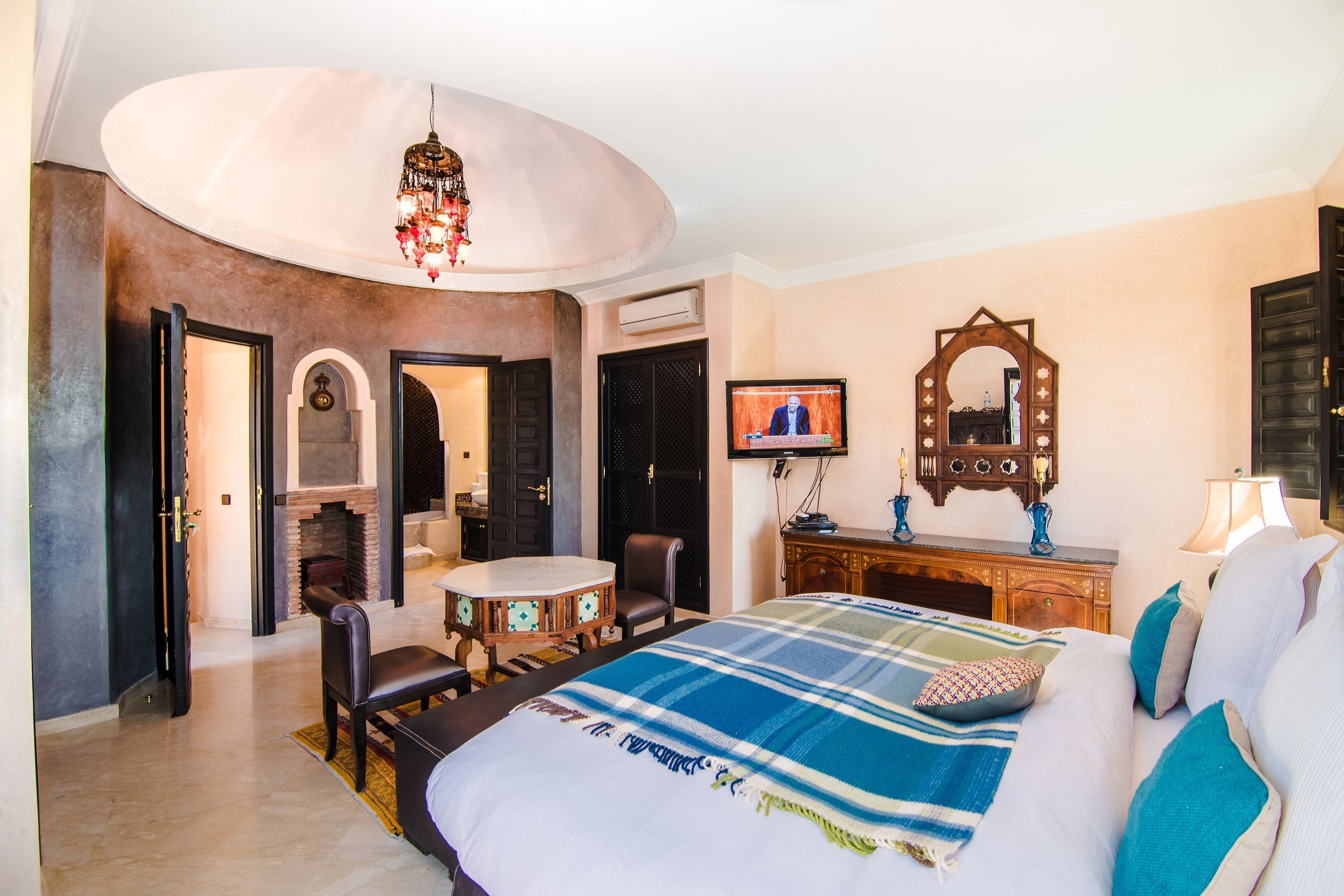 Habitación de hotel con una cama grande, una mesa de comedor, una chimenea y un televisor.