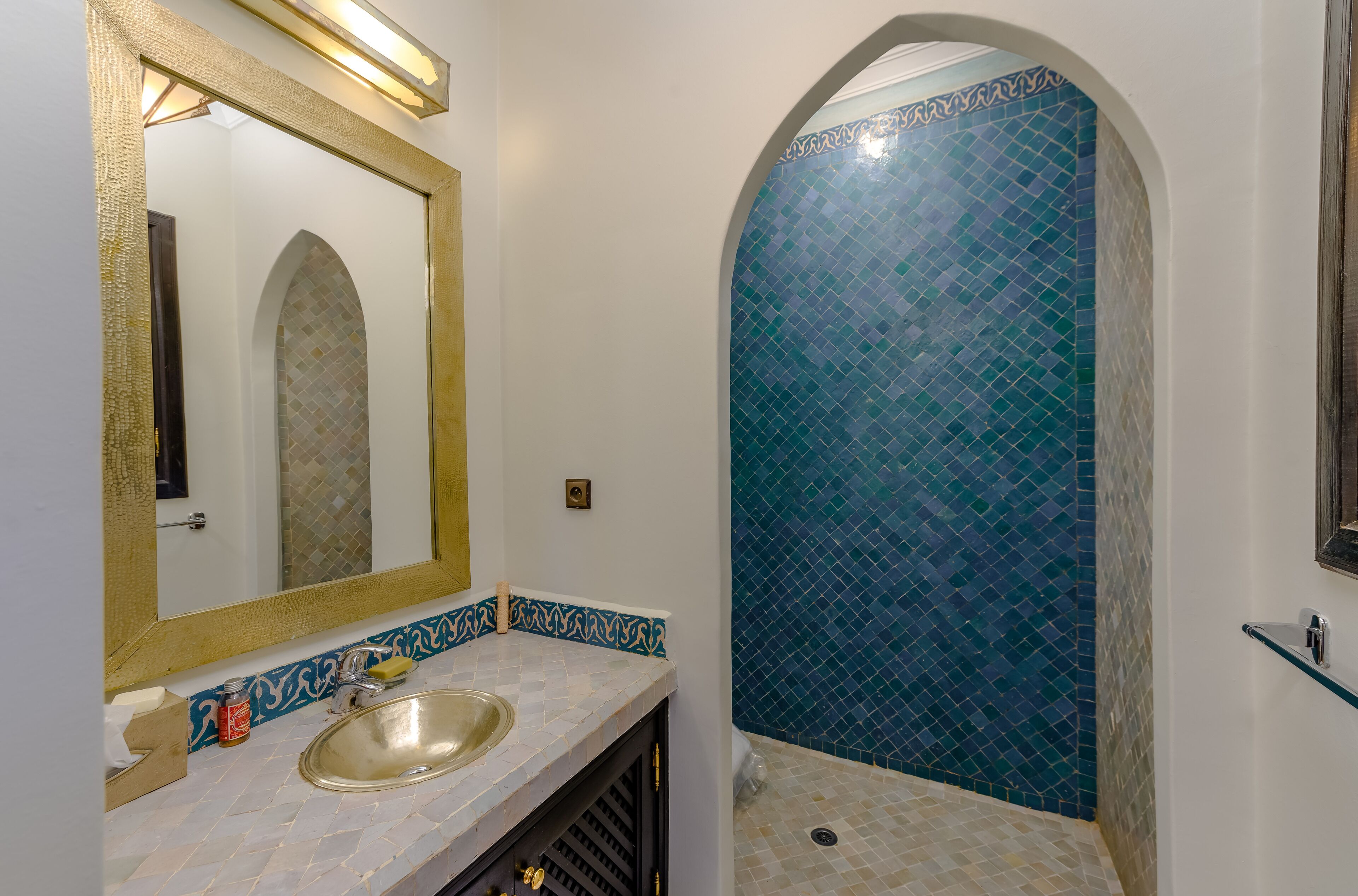Un bagno con lavandino, specchio e pareti piastrellate.