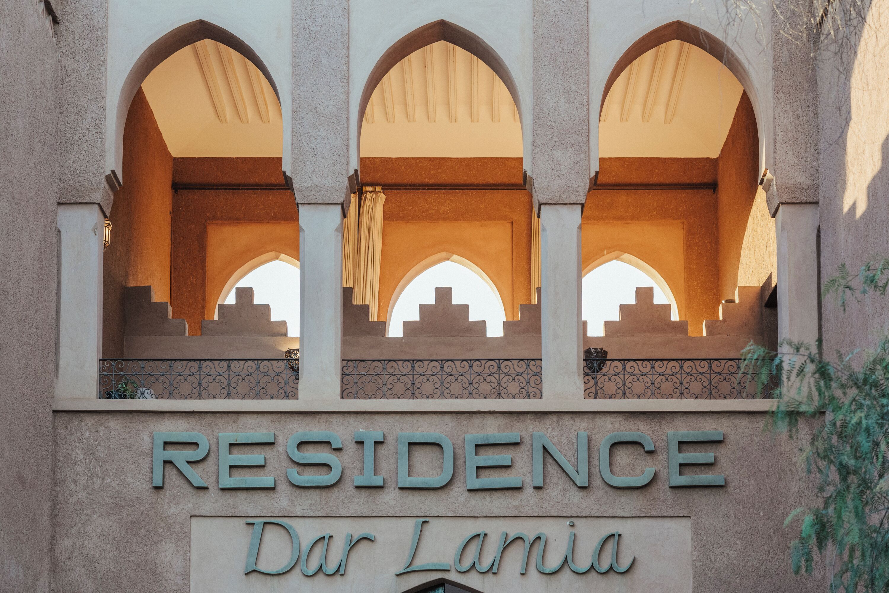 A building entrance with the sign 'RESIDENCE Dar Lamiya' and three arches.