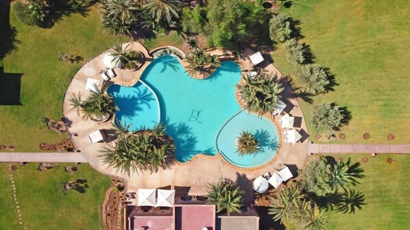 An aerial view of a resort with a large pool surrounded by palm trees and sun loungers. - Résidence Dar Lamia Marrakech (Marrakech)