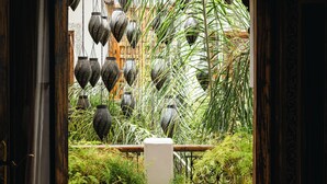 An arched doorway leading to a courtyard with hanging lanterns, patterned planters, and a tiled floor. - Riad Anya (Marrakech)