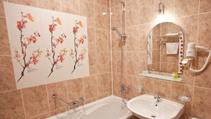 Une salle de bain avec une baignoire, un lavabo, des toilettes et une douche.