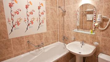 A bathroom with a bathtub, a sink, a toilet, and a shower.