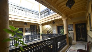 A multi-level atrium with ornate railings and a staircase. - Essaouira Wind Palace (Essaouira)