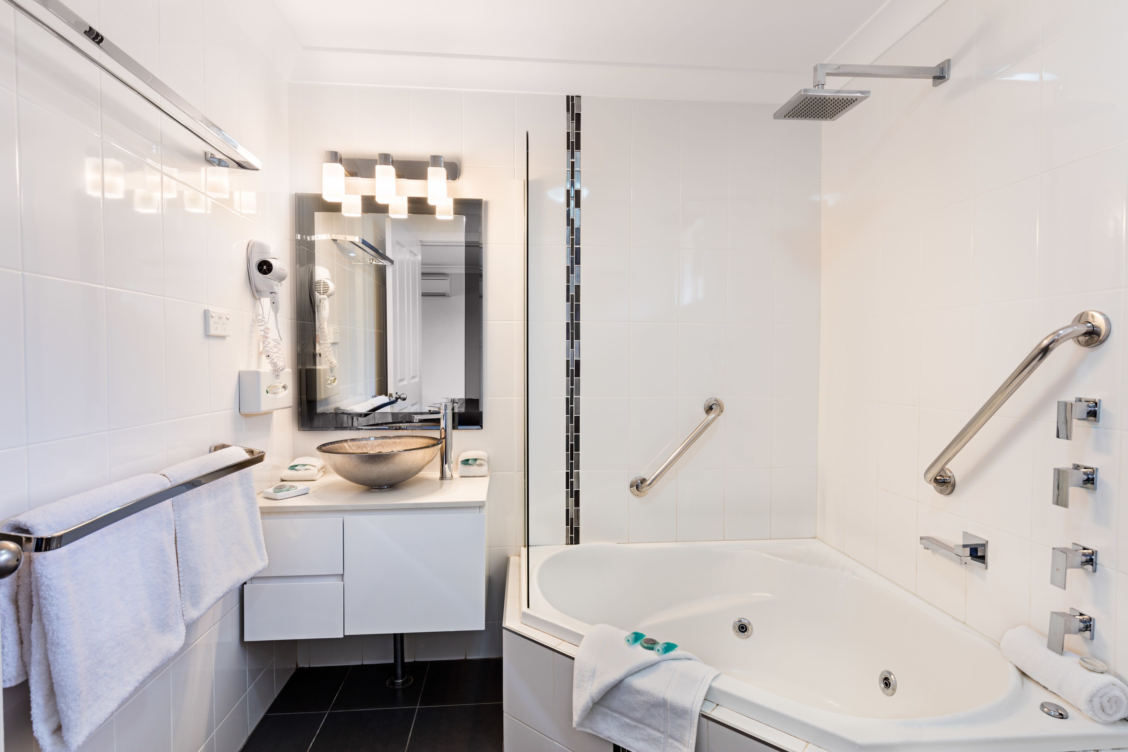 Un baño moderno con bañera, tocador con espejo y cabina de ducha.