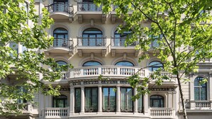 Un hotel histórico con balcones ornamentados, ventanas amplias y una fachada clásica.