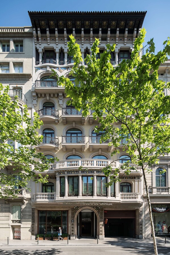 Um hotel histórico com varandas ornamentadas, janelas amplas e fachada clássica.