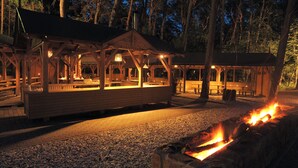 A wooden pavilion with benches and a fire pit. - Hotel Orle (Gdansk)