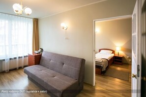 A cozy room with a sofa, a bed, and a small desk. - Hotel Orle (Gdansk)