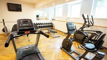 A gym with treadmills, an elliptical, and a bench press.