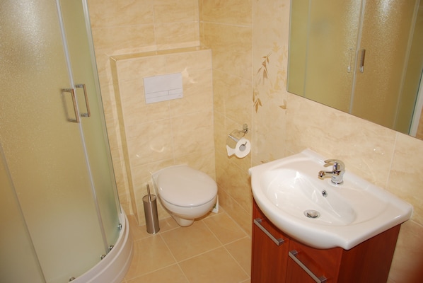 A bathroom with a toilet, sink, and shower. - Ośrodek hotelowy Optima (Kraków)