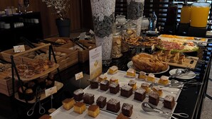A buffet with various baked goods and pastries, including brownies and muffins, arranged on a table with serving utensils. - Douro Marina Hotel & SPA (Resende)