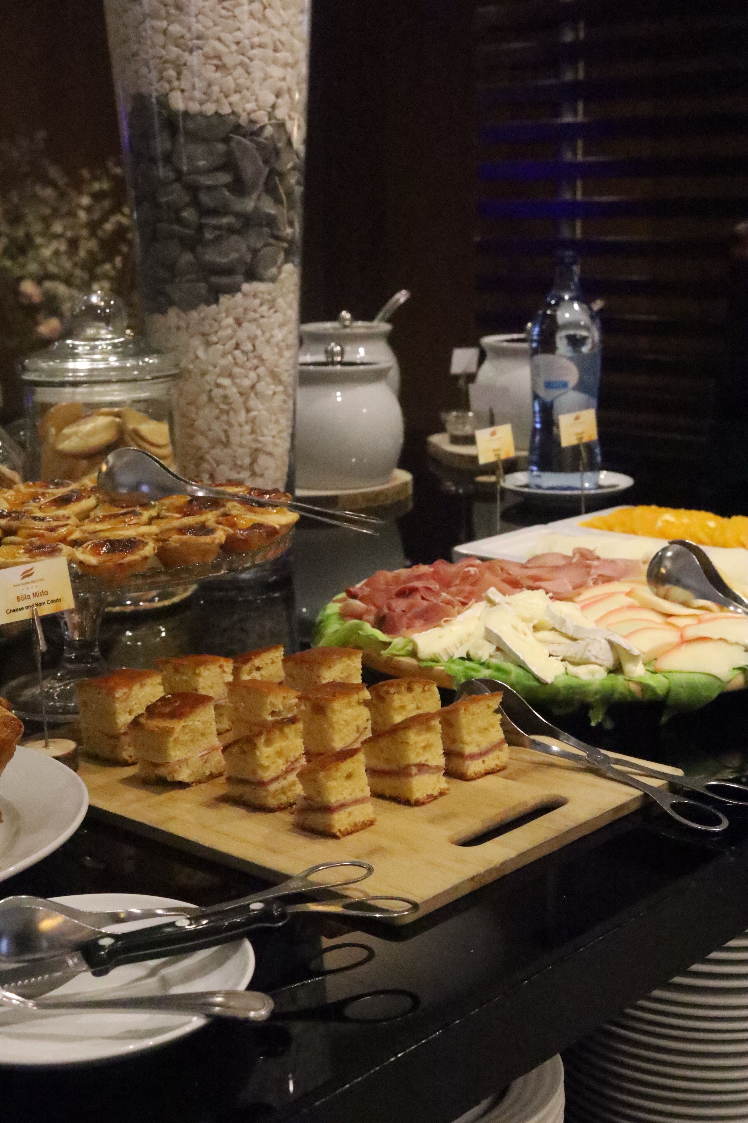 Un bufé con diversos alimentos, incluyendo queso, carnes y postres.