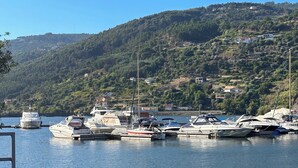 A marina with several boats docked, surrounded by hills and a clear sky. - Douro Marina Hotel & SPA (Resende)