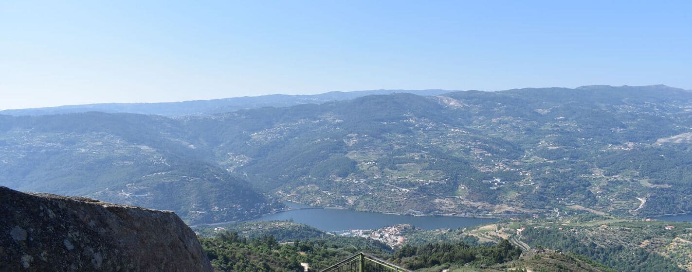 A mountainous landscape with a lake and a bridge.