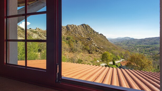 Una habitación con un ventanal que ofrece vistas a un paisaje montañoso.