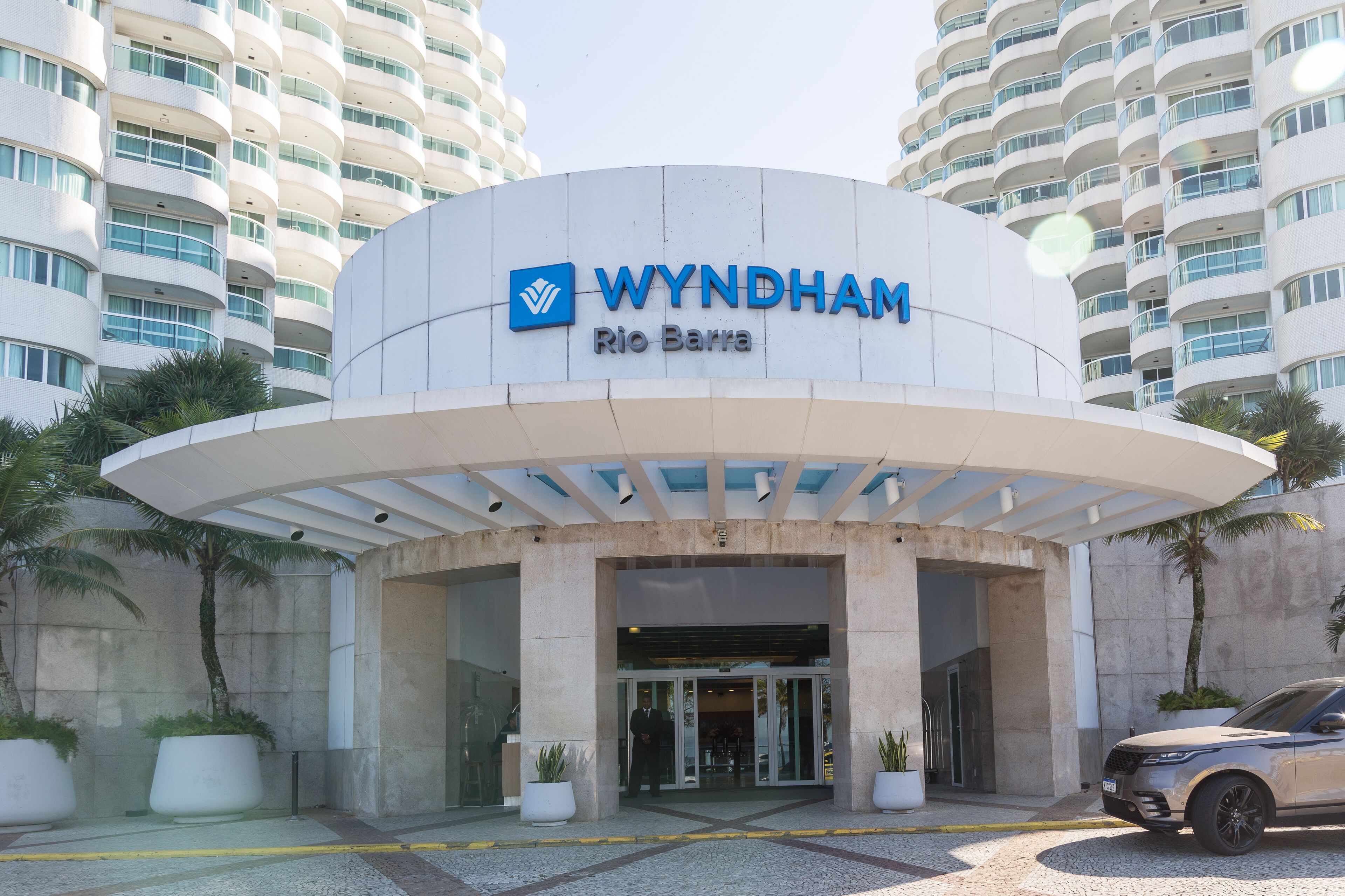 Eingangsbereich des Wyndham Rio Barra Hotels mit modernem Design, inklusive einer geschwungenen Fassade und großzügigem Eingang.