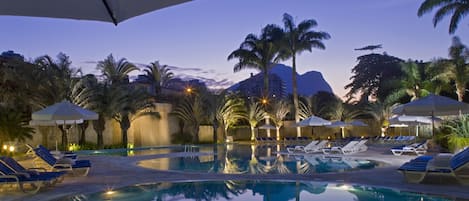 Una piscina al aire libre de temporada, sombrillas