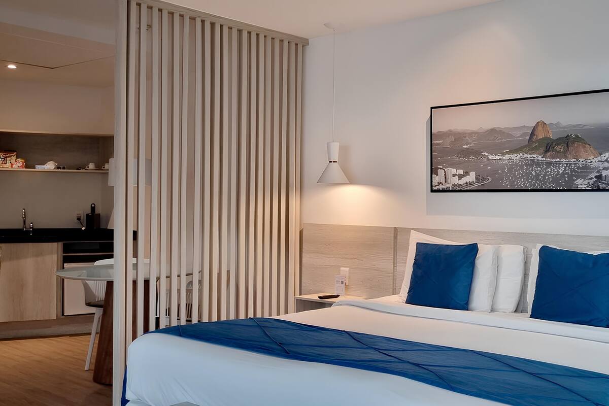 Ein Hotelzimmer mit einem Bett, einem Schreibtisch und einer Küchenzeile.