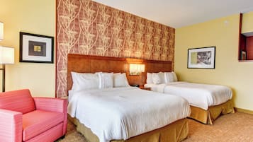 Ein Hotelzimmer mit zwei Betten, einem roten Sofa und einer Wand mit Muster.