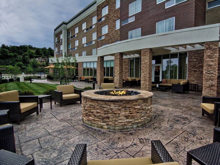An outdoor patio area with stone flooring, fire pit, and outdoor seating.