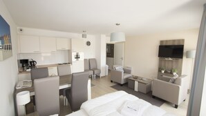 A modern hotel room with a bed, a desk, a chair, a sofa, and a TV. - Evancy Bray-Dunes (Bray-Dunes)