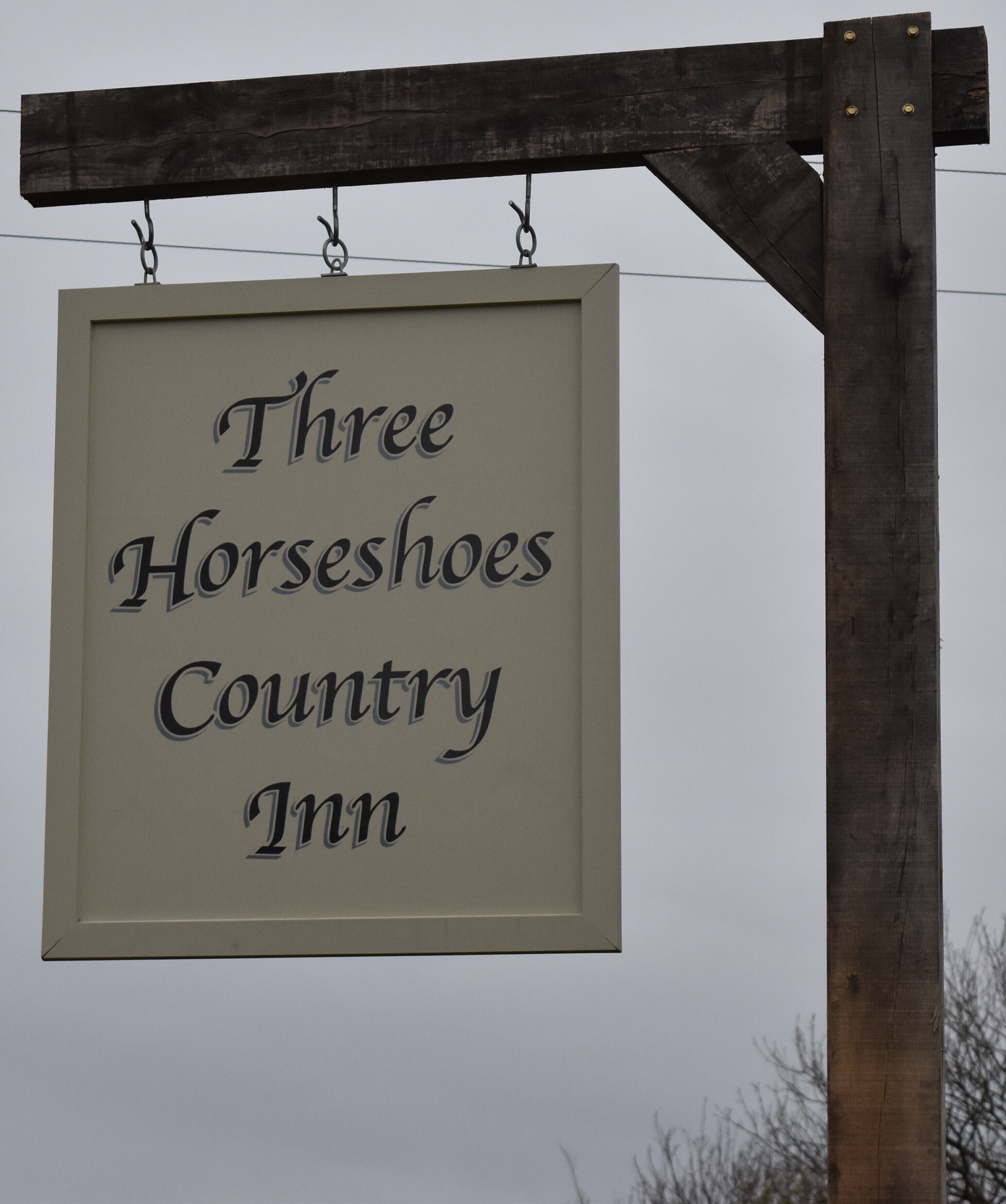 A sign for the Three Horseshoes Country Inn.