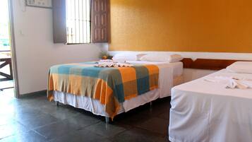 Una habitación de hotel con dos camas, una ventana con rejas y piso de baldosas.