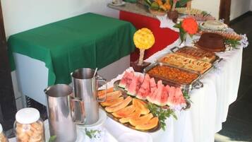 Una mesa de buffet con diversos alimentos y una jarras.