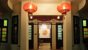 A hotel entrance with traditional Chinese lanterns, a tiled floor, and a sign with a circular logo. - G-Inn (George Town)