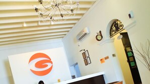 A reception area with a chandelier, a reception desk, and a patterned floor. - G-Inn (George Town)
