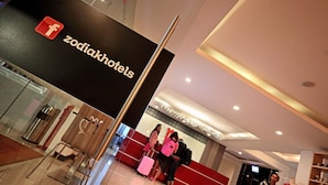 Een hotel receptie met een bordje 'zodiachotels' en een modern interieur.