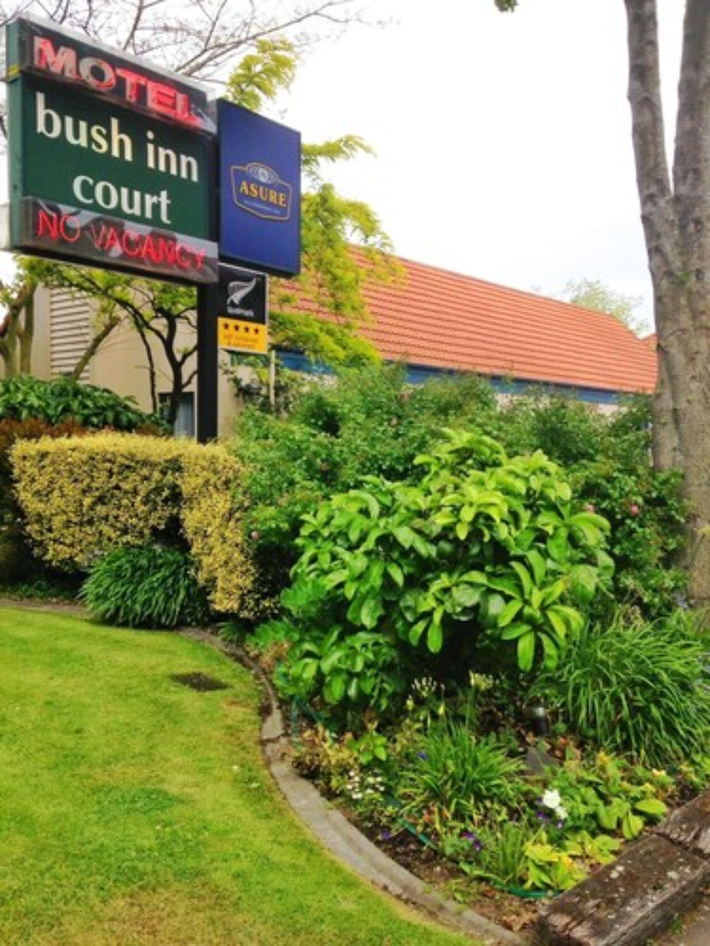 A motel sign for Bush Inn Court with a no vacancy notice.
