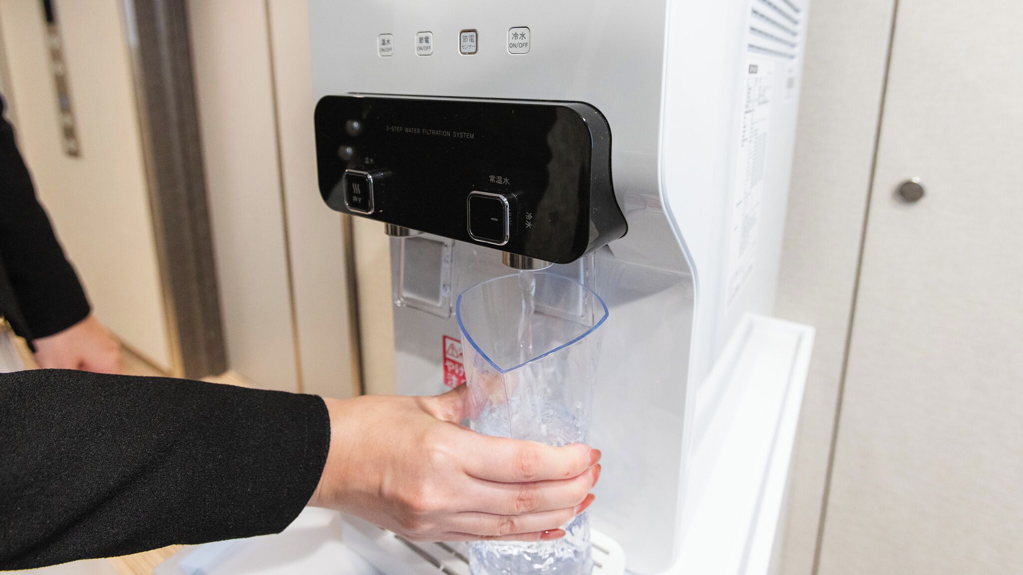 A water dispenser with a clear plastic bottle being filled.