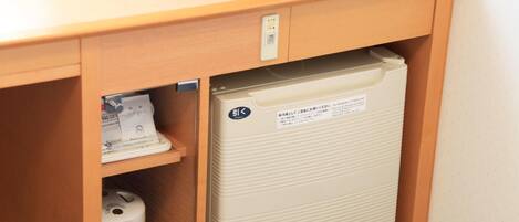 Un refrigerador compacto con un panel de control y una cafetera, todo integrado en un mueble de madera.