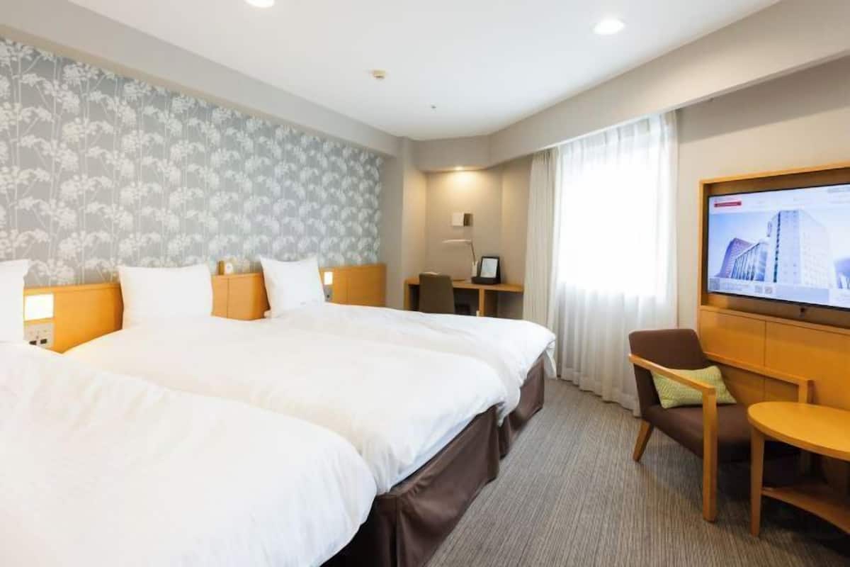 Cubrecamas, escritorio y espacio para trabajar con laptop