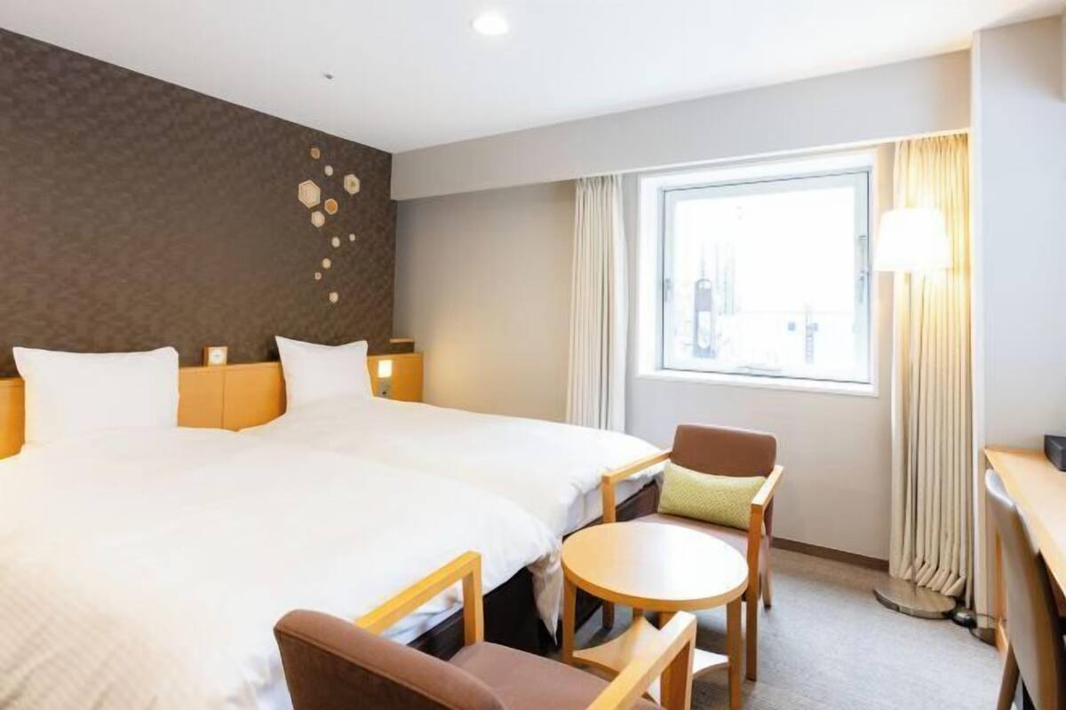 Cubrecamas, escritorio y espacio para trabajar con laptop