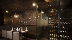 A modern dining area with a glass partition, wooden ceiling, and a wine rack filled with bottles. - Oak Tree Urban Jakarta (Jakarta)
