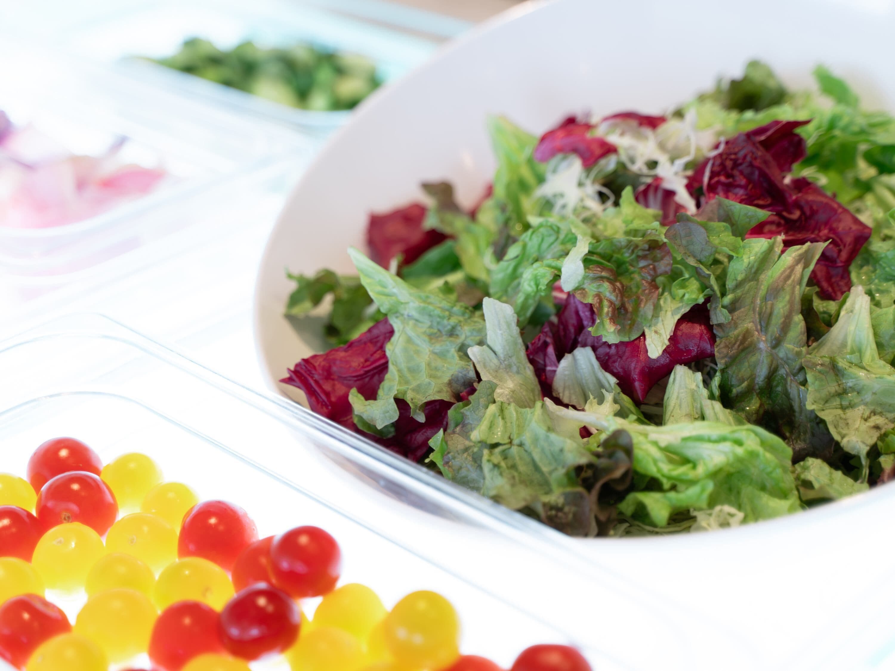 A salad bowl with mixed greens and cherry tomatoes.