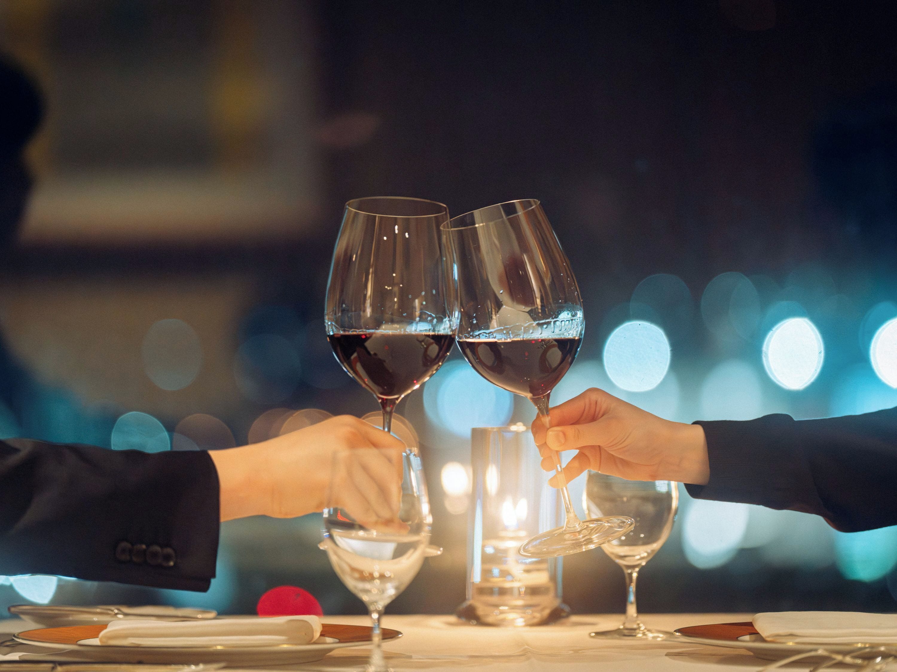A table with wine glasses and a red object, possibly a fruit.