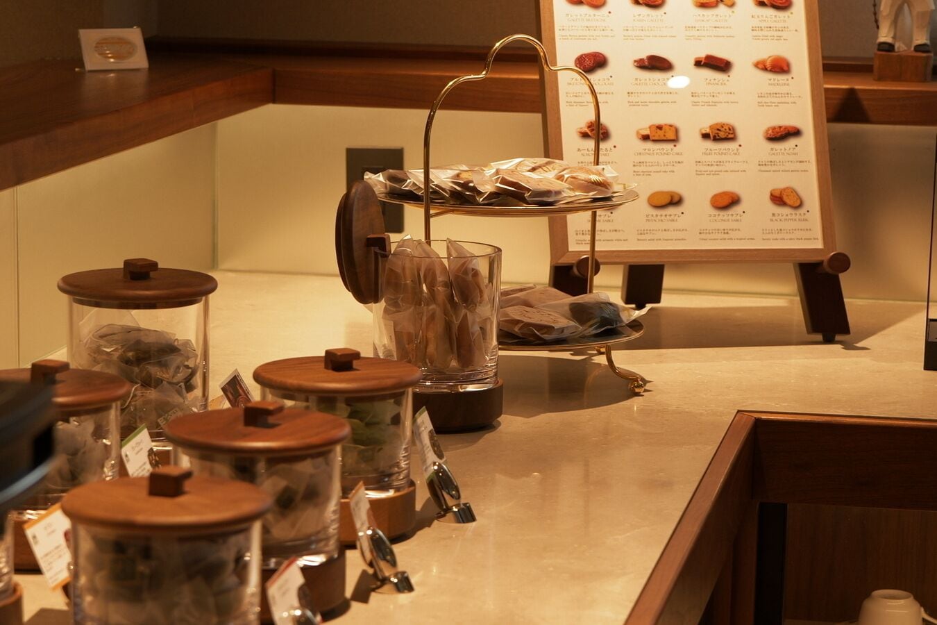 A counter with jars of snacks, a menu board, and a glass display.