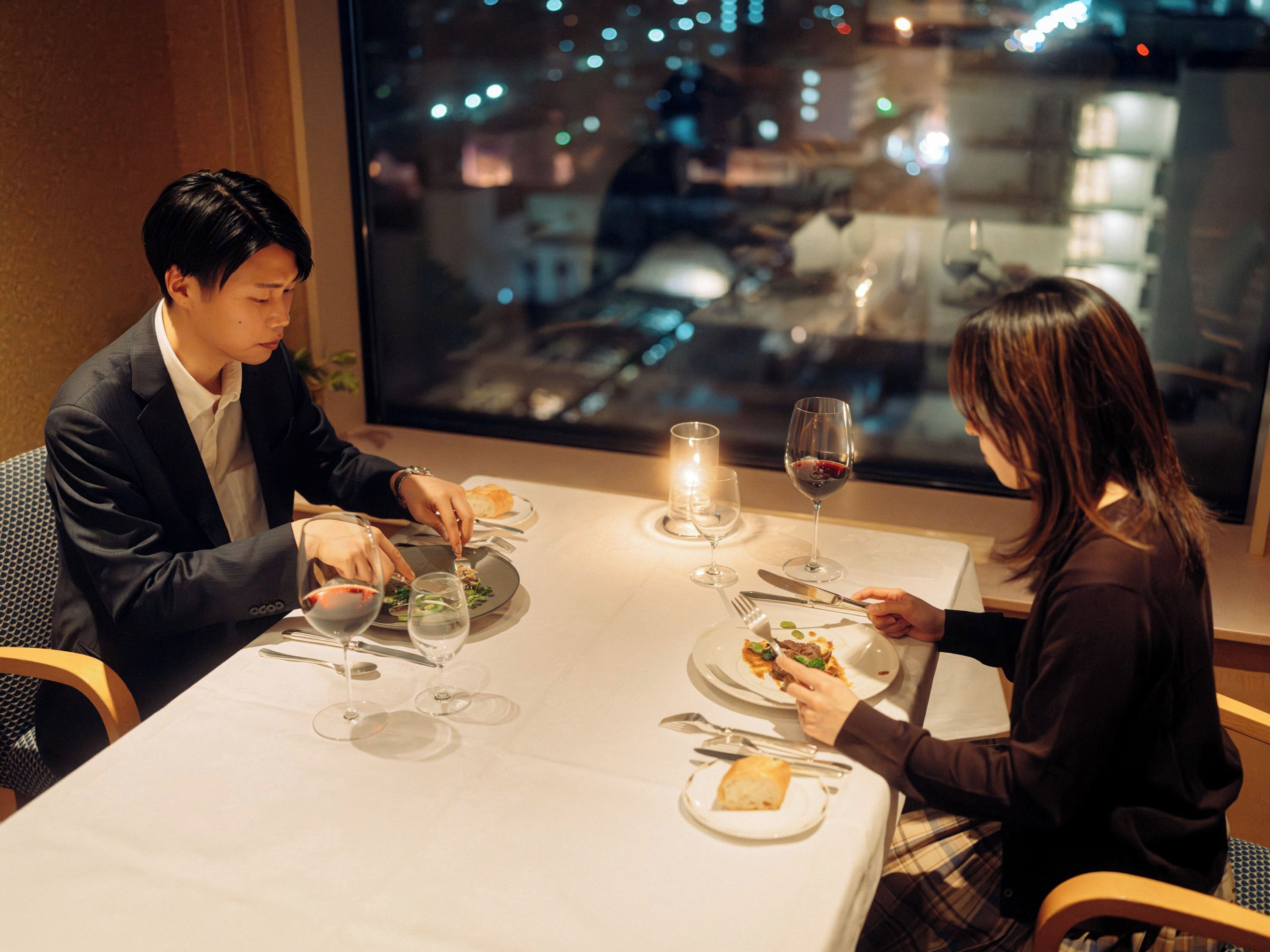 A dining table with plates, glasses, and cutlery.