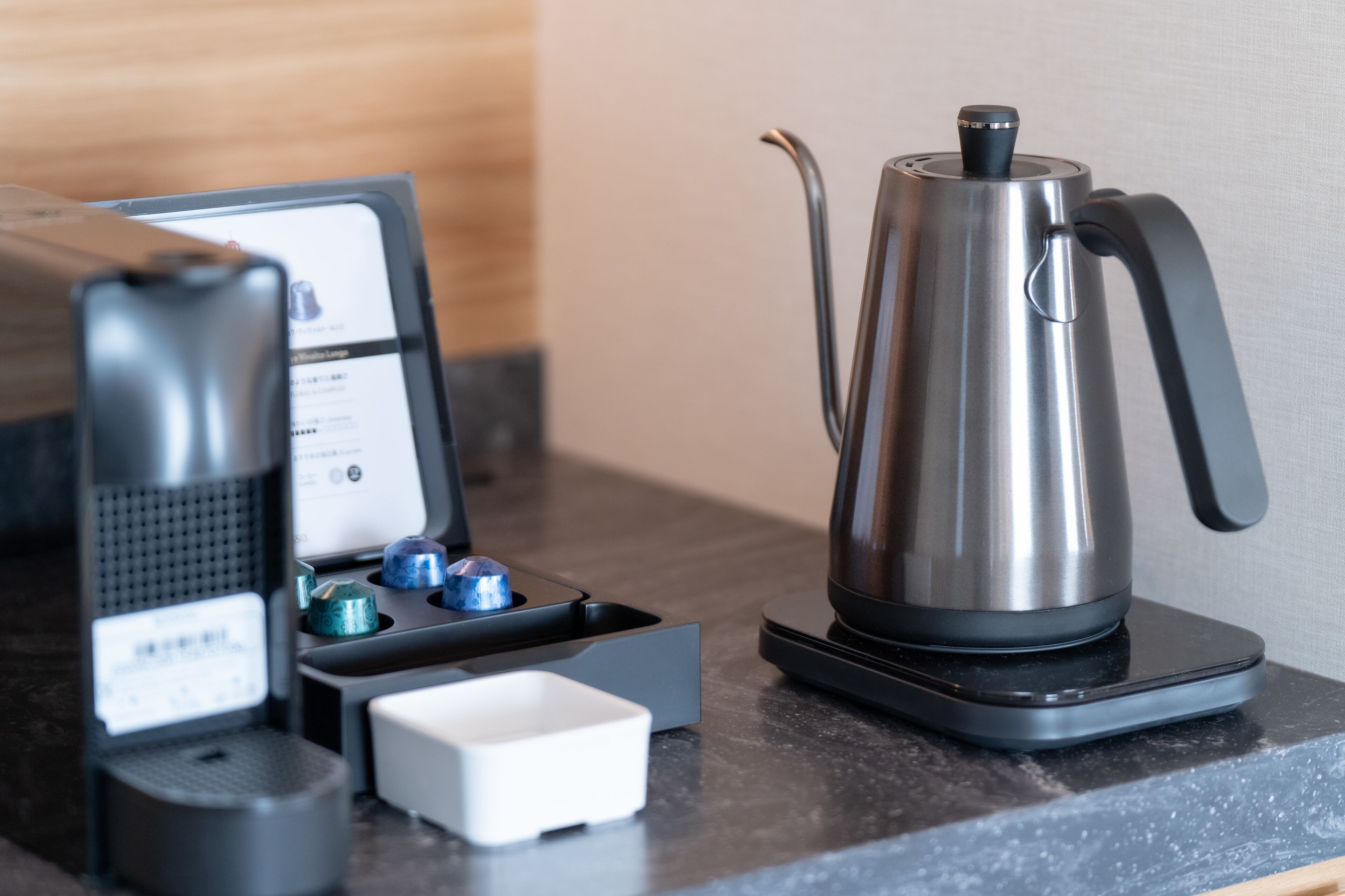 Eine Kaffeemaschine und ein Wasserkocher auf einer Arbeitsfläche.