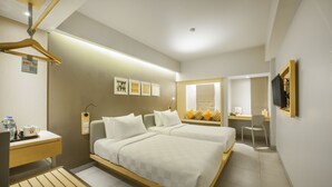 A hotel room with two beds, a desk, a chair, a TV, and a bathroom. - Sevn Legian (Legian)
